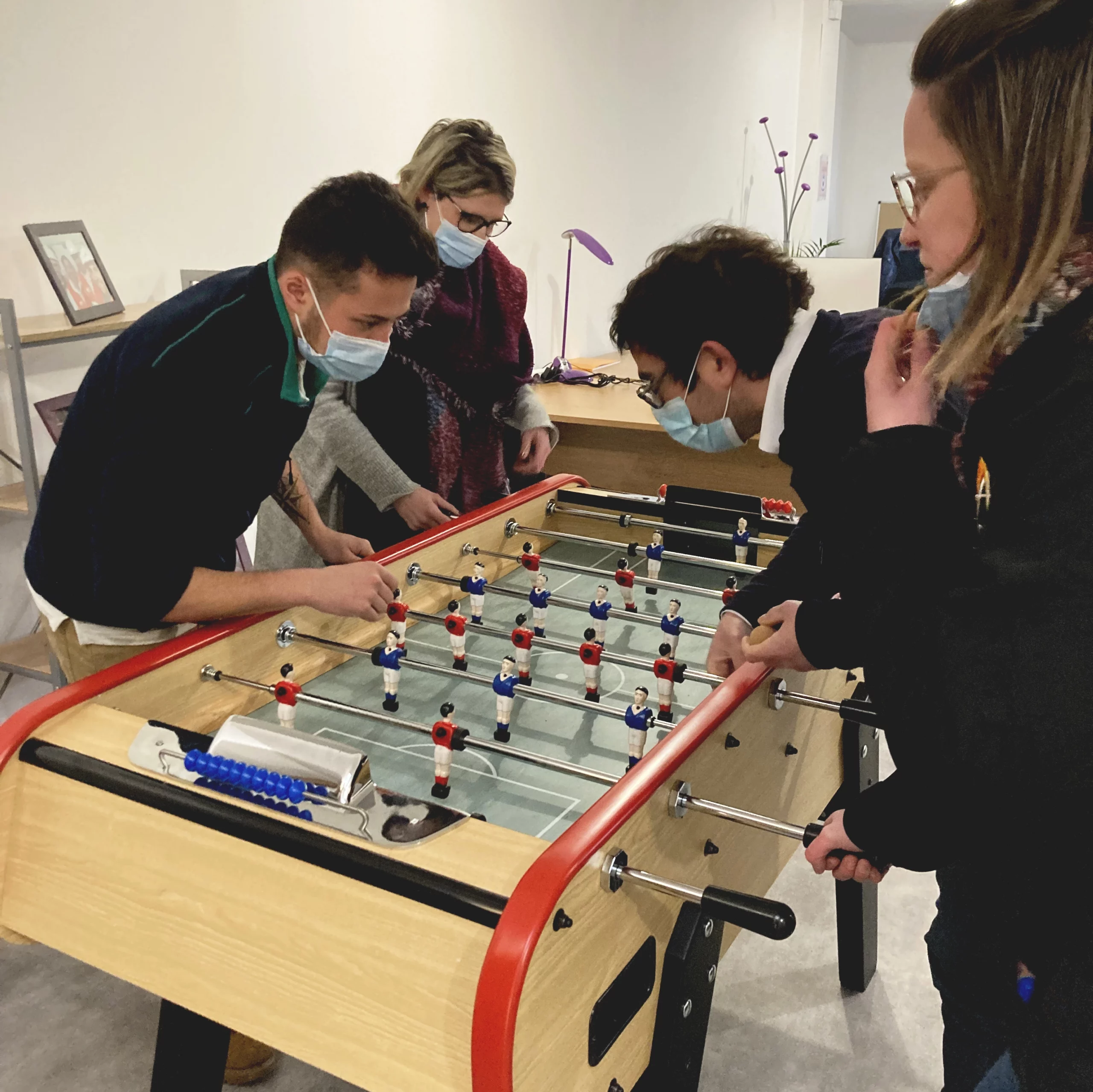 Photo de 4 collaborateur en train de jouer au babyfoot à noël